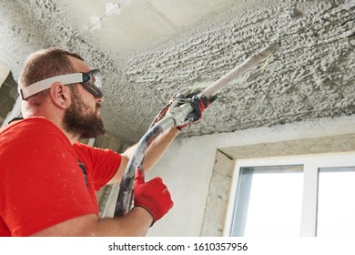 Plasterer Using Sprayer Machine Putting Plaster Mortar On Ceiling