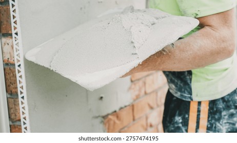 Plastering, Construction, Render, Worker, Mortar, Wall, Trowel used by a professional tradesman applying fresh cement to an exterior brick surface during a home renovation project.