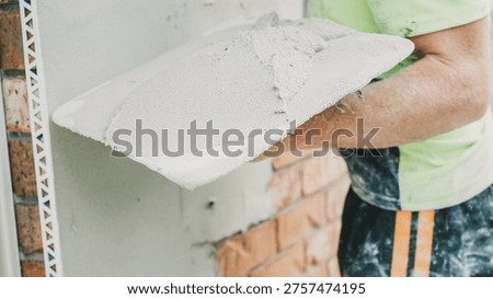 Plastering, Construction, Render, Worker, Mortar, Wall, Trowel used by a professional tradesman applying fresh cement to an exterior brick surface during a home renovation project.