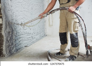 Plastering The Interior Wall With An Automatic Spraying Plaster Pump Machine