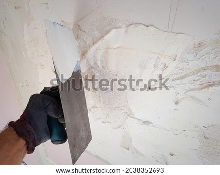 Plastering the wall. Applying plaster to the wall. Spatula. Smoothing uneven walls. Renovating of interior. Renovation. Concrete trowel in mans hand. Worker buliding wall.