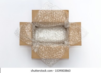 Plastic Air Bubble Wrapped Items In A Brown Cardboard Box, Ready To Be Shipped.