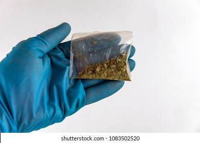 Plastic Bag Of Synthetic Smoking Substances In Hand: Cannabis, Weed, Marijuana. On White, Top View