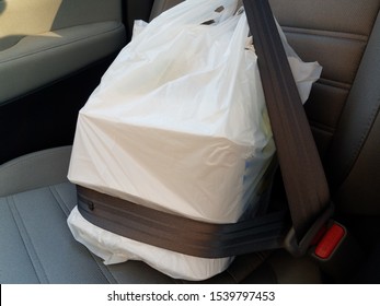 Plastic Bag With Take Out Or Delivery Or To Go Food In Seatbelt In Car