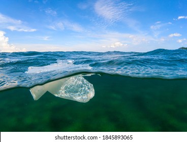 Plastic Bag In Tropical Seawater, Split Photo Above And Below Sea Water Level. Tropical Island Ecological Problem. Plastic Pollution In Ocean. Human Impact On Wild Nature. Coral Reef Endangered Life