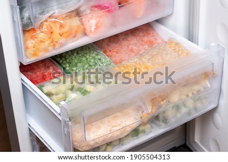 Plastic bags with different frozen vegetables in refrigerator. Food storage