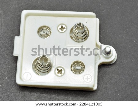 Plastic battery lid with metal bolts and metal spring contacs