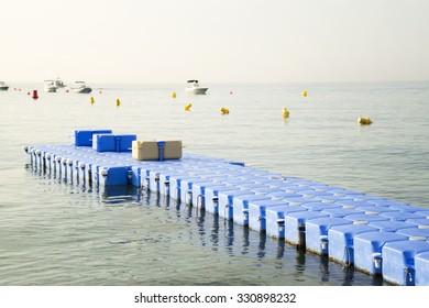 Plastic Blue Rotomolding Jetty In The Empty Sea Against Blue Sky.