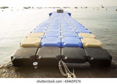 Plastic Blue Rotomolding Jetty In The Empty Sea Against Blue Sky.