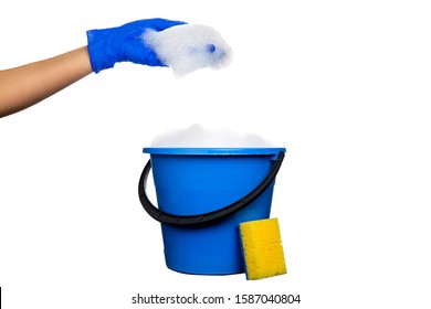 Plastic Blue Water Bucket With Soapsuds And Black Handle. Cleaning Products And Supplies. Gloved Hand With Soap Suds. Isolated White Background