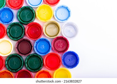 Plastic bottle caps on white background. Cap material is recyclable. Recycling collection and processing plastic bottle caps. Remove lids from plastic bottles before recycling them. - Shutterstock ID 2163832827