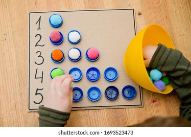 Plastic bottle caps. Put correct  amount pom poms  in cups. 5 minute carfts. DIY children home activity. Early education, counting game, fine motoric skills. #stay at home.