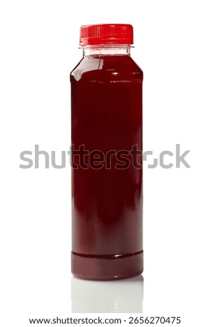 Plastic bottle containing red cherry juice on white background