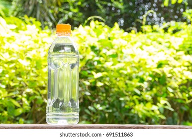Plastic bottle of drinking water and burred nature background