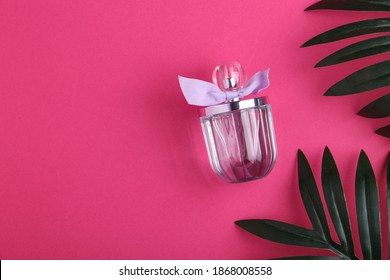 Plastic Bottle Of Facial Moisturizing, Hair Spray Or Body Mist And Green Herbal Leaves Isolated On Pastel Pink Background, Flay Layout, Top View, Copy Space, Natural Organic Beauty Product