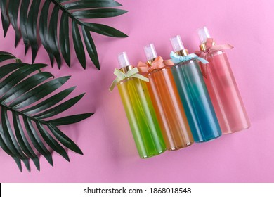 Plastic Bottle Of Facial Moisturizing, Hair Spray Or Body Mist And Green Herbal Leaves Isolated On Pastel Pink Background, Flay Layout, Top View, Copy Space, Natural Organic Beauty Product