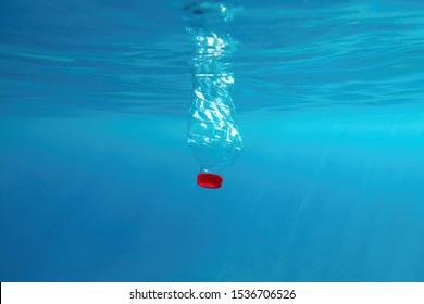 Plastic Bottle Floating In The Blue Sea Water. World Ocean Contaminated By  Plastic. Environment Pollution Concept.