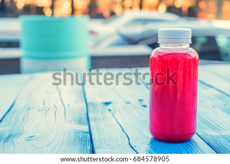 Plastic bottle with red fruit drink in restaurant