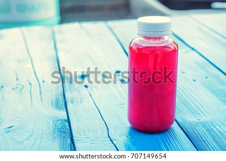 Plastic bottle with red fruit drink in restaurant