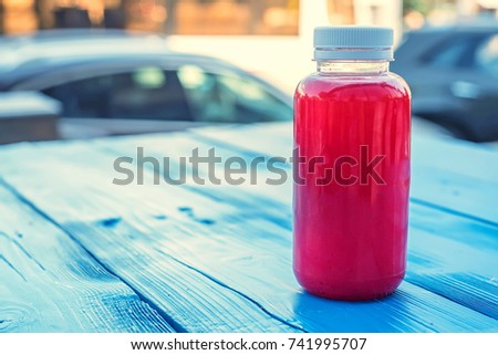 Plastic bottle with red fruit drink in restaurant