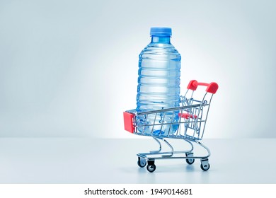Plastic bottle of water in trolley on grey background with copy space. Water Delivery.