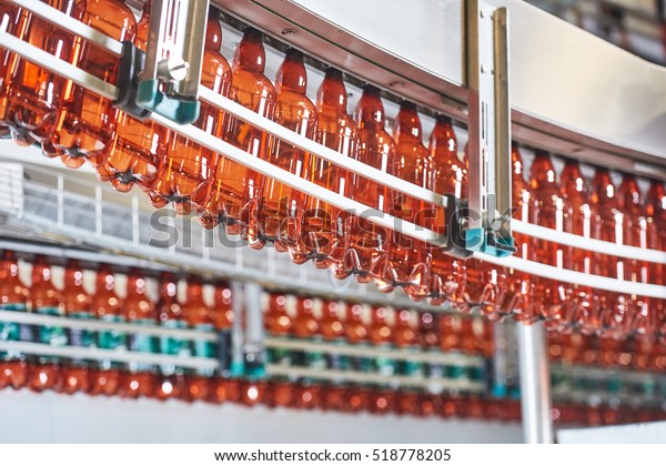 Plastic bottles for beer or carbonated beverage\
moving on conveyor