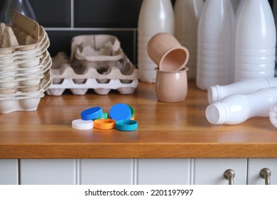 Plastic Bottles, Colored Plastic Caps And Egg Carton Boxes On The Kitchen. Plastic Waste Collected And Prepared For Recycling. 