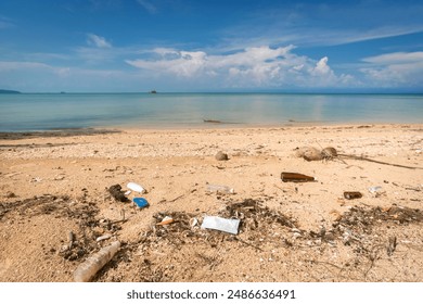 Plastic bottles and face mask lie on the beach and pollute the sea and marine life. Garbage rubbish trash problem environmental pollution. Concept of pollution control of the sea and ocean by plastic. - Powered by Shutterstock