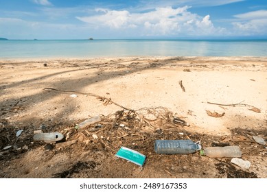 Plastic bottles and face mask lie on the beach and pollute the sea and marine life. Garbage rubbish trash problem environmental pollution. Concept of pollution control of the sea and ocean by plastic. - Powered by Shutterstock