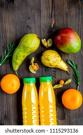 plastic bottles with fruit drinks on wooden background top view 