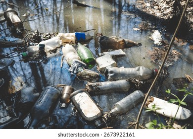 Plastic bottles and garbage floating in a forest pond. Polluted water against the background of trees. Catostrafichesky ecological problem. Pollution of water bodies. Plastic garbage.