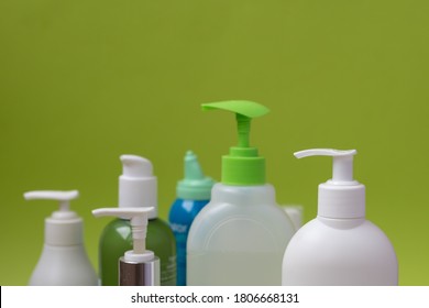PLastic bottles and packs agaist green background with empty space, consumering a lot