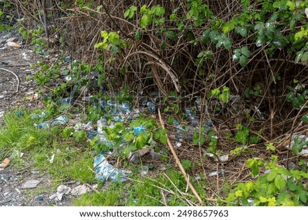 Plastic bottles and trash littering a forest floor with green foliage. Litter in the park. Concept of environmental pollution, waste management, and nature conservation. High quality photo