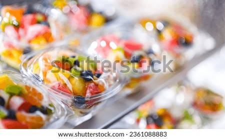 Plastic boxes with pre-packaged fruit salads, put up for sale in a commercial refrigerator