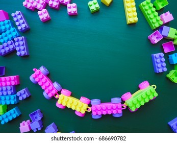 plastic bricks at the table. Early learning. stripe background. Developing toys