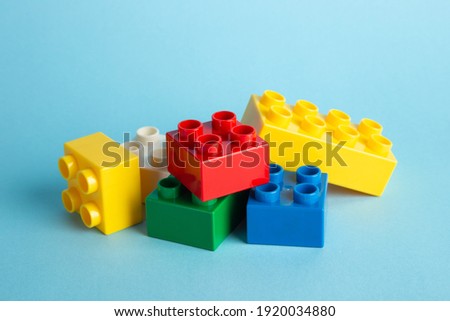 Plastic building blocks on blue background