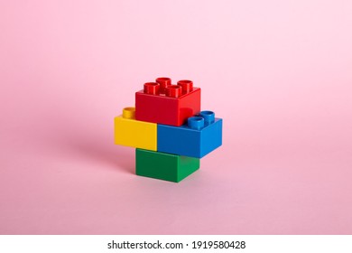 Plastic building blocks on pink background