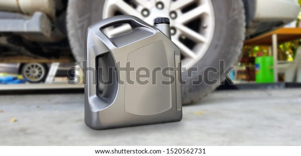 Plastic canister for motor machine oil in\
the front of the garage in the background,Oil change service and\
repair. Engine oil sign for\
advertising.