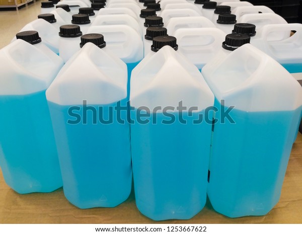 Plastic cans filled with blue liquid, cleaning and\
washing of Windows, glass and surfaces. A large group of goods in\
the store.