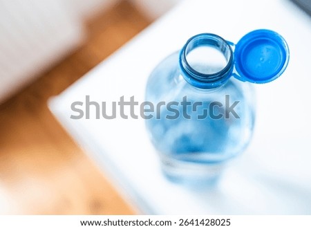 Plastic cap connected to a plastic bottle. Bottle design with the cap attached to the bottle for easier recycling of waste.