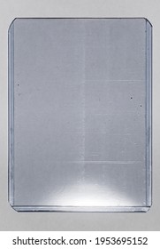 Plastic Card Toploader Case On White Paper Background, Gaming Or Trading Card Placeholder With Nice Light Reflection.