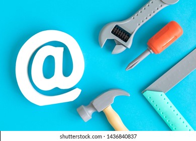 Plastic carpentry tools and email symbol abstract isolated on blue.