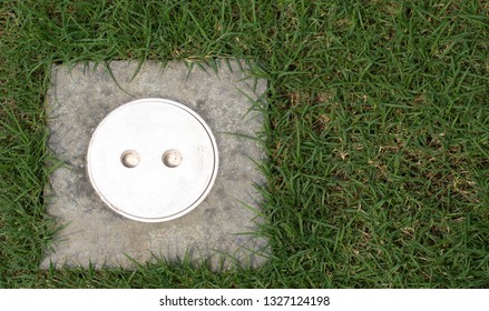 Plastic Clean Out Cap Cover For Water Septic Tank On Concrete Plate Square With Green Grass Lawn Outside House 