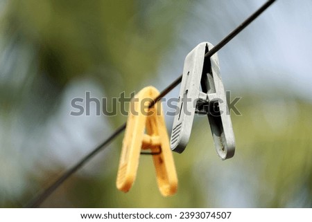 Plastic Clothespin on a hanger. Colored old cloth clips on a cloth rope.