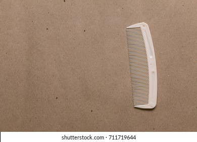 Plastic combs is placed on a brown background.