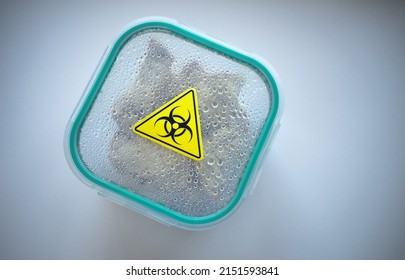 A Plastic Container With Food Marked With A Yellow Radiation Sign.Contaminated Food. The Danger Of Radiation In A Container On A White Isolate.