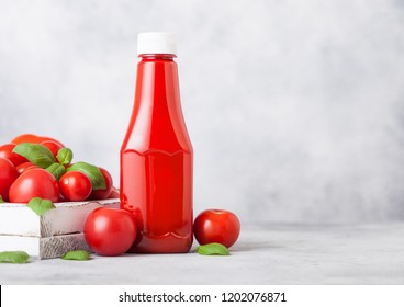 Plastic container with tomato ketchup sauce with raw tomatoes on kitchen background.