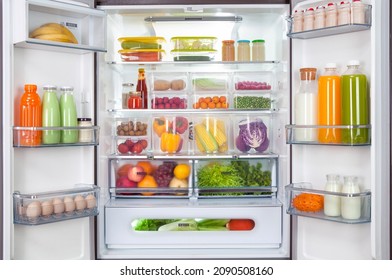 Plastic Containers With Different Fruits And Vegetables In A Open Fridge. Frozen Food Storage.