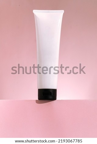 Plastic cosmetic tube for cream or gel mockup on pink background