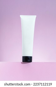 Plastic cosmetic white tube for cream or gel mockup on pink background
